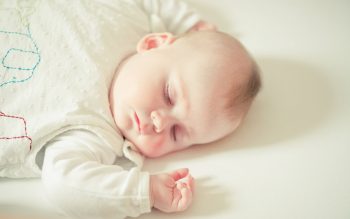 White Cute Baby Sleeping on Bed Wallpaper
