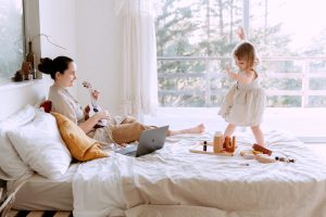 Happy Young Woman Playing With Daughter At Home